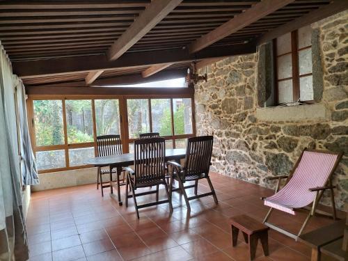 艾斯特拉达Casa Rural A Telleira的用餐室设有椅子、桌子和窗户