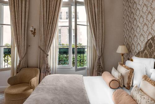 巴黎克里斯蒂娜驿站酒店的卧室配有床、椅子和窗户。