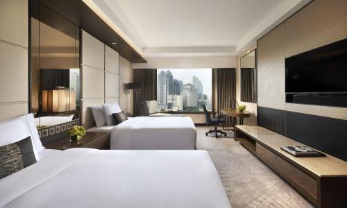 雅加达ARTOTEL Suites Mangkuluhur Jakarta的酒店客房设有两张床和电视。