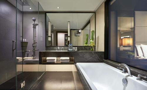 雅加达ARTOTEL Suites Mangkuluhur Jakarta的一间带浴缸和大镜子的浴室