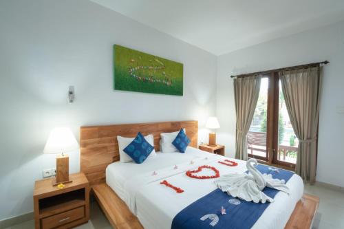 乌布青木瓜之家民宿的一间卧室配有一张带天鹅装饰的床。