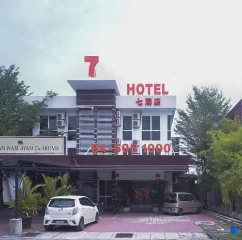 Juru7 Hotel的前面有两辆车的酒店
