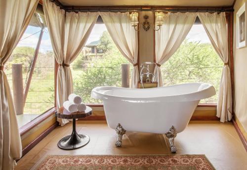 ManyaraTARANGIRE KURO TREETOP LODGE的窗户前设有带浴缸的浴室