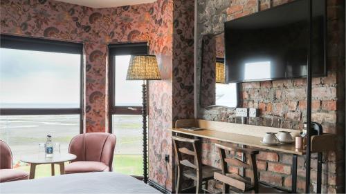 纽卡斯尔Avoca Hotel的一间卧室设有砖墙和桌椅