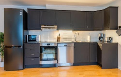 特罗姆瑟City Square的厨房配有不锈钢用具和黑色橱柜