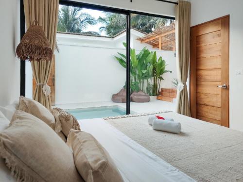 爱妮岛Bahala Na Villas的一间卧室设有一张床和一个游泳池
