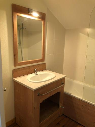 圣索林达尔沃Chalet cosy Duplex 6 personnes的浴室配有盥洗盆、镜子和浴缸