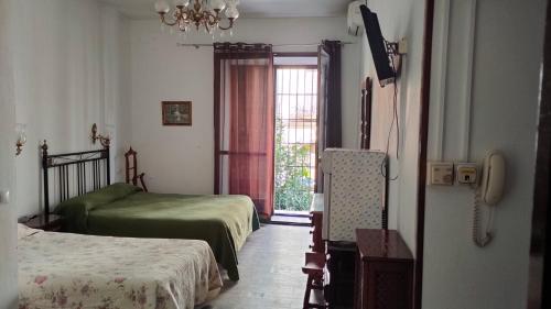 安特克拉科隆安特克拉酒店的一间小卧室,配有两张床和窗户