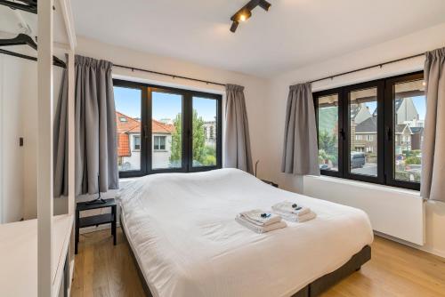 科克赛德Sublieme, ruime luxe villa 10p met terras én tuin的一间卧室设有一张床和大窗户