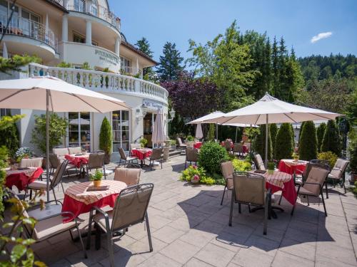 福森拜德法勒巴赫酒店的一个带桌椅和遮阳伞的户外庭院。