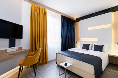 布达佩斯KViHotel Budapest - the smart hotel的一间酒店客房,配有一张床和一台电视
