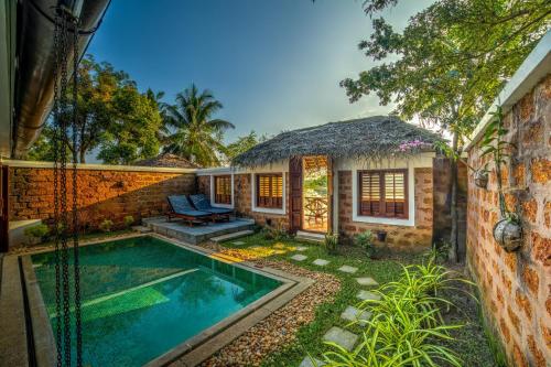 库玛拉孔Coconut Lagoon Kumarakom- CGH Earth的一座带游泳池和房子的度假屋