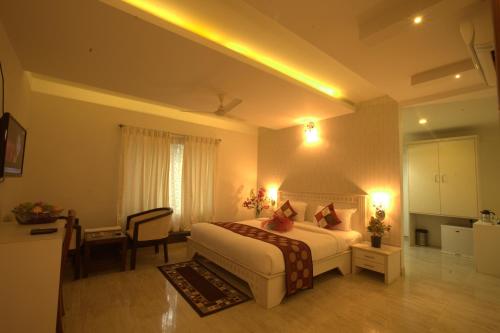 班加罗尔Royal shades kodihali的酒店客房配有一张床、一张书桌和一间厨房。