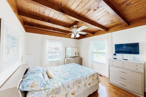 橡树岛Ginny's Coastal Cottage的一间卧室设有一张床和木制天花板