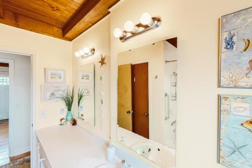 橡树岛Ginny's Coastal Cottage的带浴缸、水槽和镜子的浴室