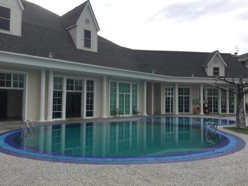 金宝Home Feel-Lavenders Suites的一座房子前面设有游泳池