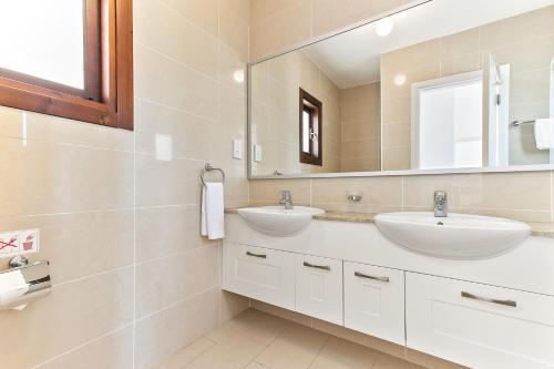 库克里亚2 bedroom Apartment Anatoli with communal pool, Aphrodite Hills Resort的浴室设有2个水槽和镜子
