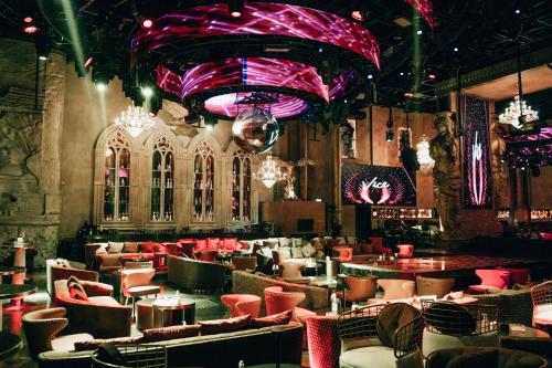 迪拜Ramee Dream Hotel Downtown的餐厅拥有红色的灯光和桌椅