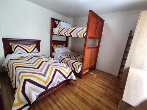 洛哈Dulce Hogar 02的一间卧室设有两张双层床,铺有木地板。