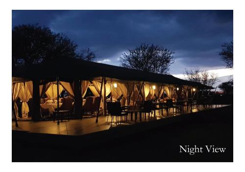 NyanunguOLE SERAI LUXURY CAMP - KOGATENDE的夜间带桌椅的帐篷