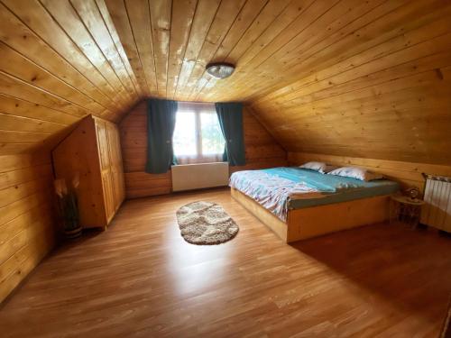 克尔茨什瓦拉乡Casa Mari的木制客房内的一间卧室,配有一张床