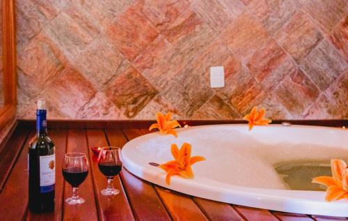 维奥康德马奥Pousada do Sonho的浴缸配有两杯葡萄酒和一瓶香槟