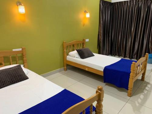 努沙再也Hud hud Homestay Gelang Patah的一间卧室设有两张床和窗户。