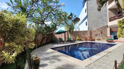 马塞约Hotel Pousada Bossa Nova的庭院内的游泳池,带椅子和树木