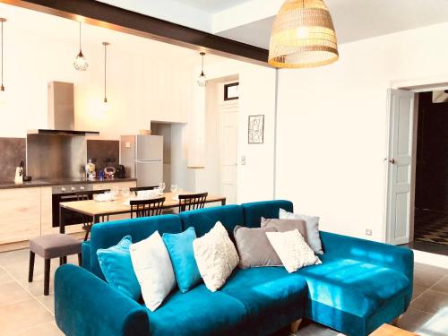 尼姆Le Pari Nîmois, avec Parking, Centre Ville Arènes的一间带蓝色沙发的客厅和一间厨房