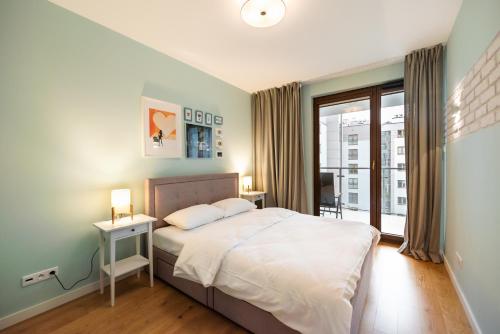 华沙Sokratesa Estate Ideal Apartment的一间卧室设有一张大床和一个窗户。