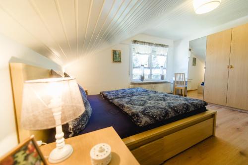 HerrischriedFerienwohnungen Am Skilift的一间卧室配有一张床和一张带台灯的桌子