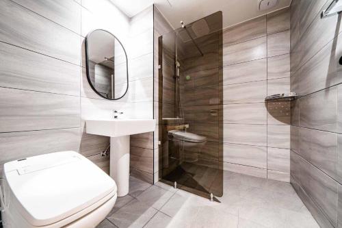 杨平郡The Amber Hotel的一间带卫生间、水槽和镜子的浴室