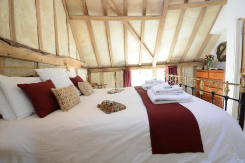 WorlingworthYew Tree Farm Barn, Worlingworth的一间卧室配有一张大床和毛巾