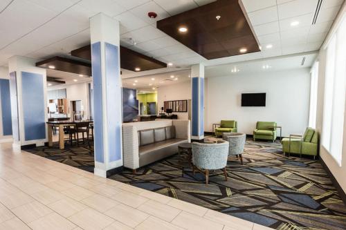 圣艾伯特Holiday Inn Express & Suites Edmonton N - St Albert, an IHG Hotel的大堂设有带桌椅的等候区