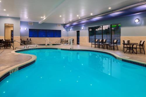 布里奇波特布里奇波特快捷假日酒店的酒店设有带桌椅的游泳池