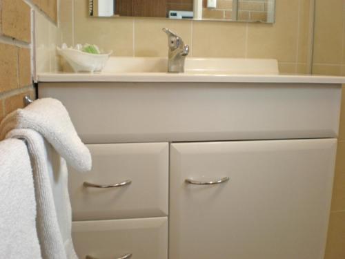 阿米代尔白灯笼汽车旅馆的一间带水槽和白色台面的浴室