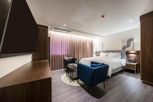 木浦市Hotel Yaja Mokpo Peace Square的配有一张床和一把椅子的酒店客房