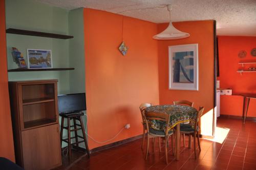 马西亚娜马里纳Cotetonda - Appartamento Taccola的一间拥有橙色墙壁和桌椅的用餐室