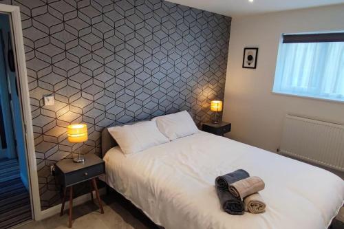 博勒姆伍德Comfortable 1 Bed flat with Air Con的一间卧室配有一张床、两盏灯和一个窗户。