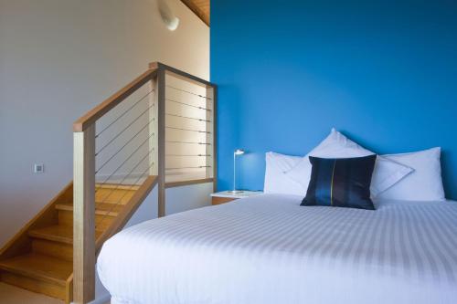 阿波罗湾克里斯比肯波恩特餐厅和别墅的一间卧室配有一张蓝色墙壁的床