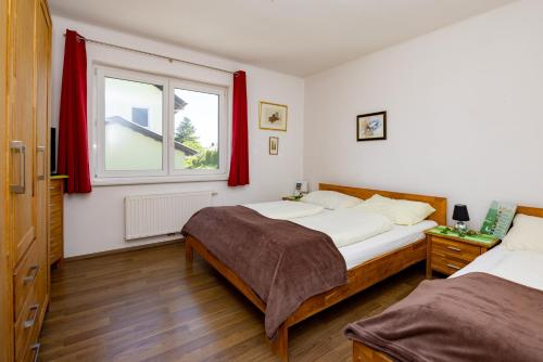 克夫拉赫克夫拉赫公寓的一间卧室设有两张床,窗户配有红色窗帘