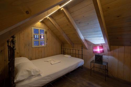 Vanáton阿哥罗艺术精品及豪华别墅的阁楼卧室配有床和灯