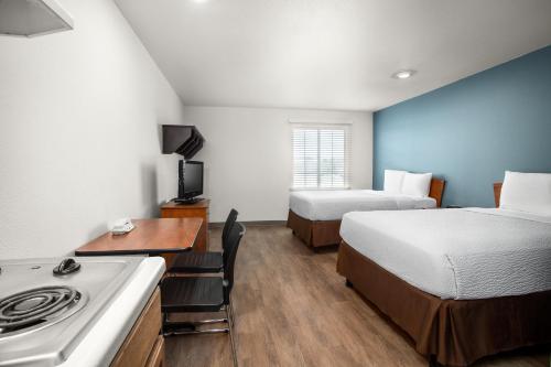 格尔夫波特Extended Stay America Select Suites - Gulfport的小型酒店客房配有两张床和炉灶。