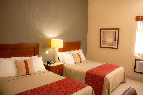 洛斯莫奇斯菲尼克斯酒店的酒店客房,设有两张床和一盏灯