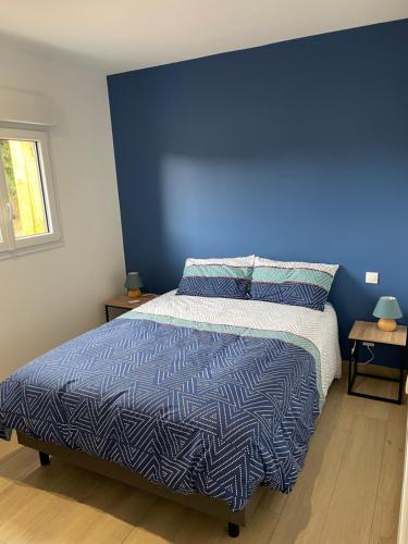Gite d Annie et J-louis的一间卧室设有蓝色的墙壁和一张床