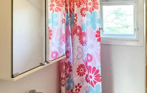 格尔斯维克4 Bedroom Stunning Home In Gressvik的带淋浴帘和窗户的浴室