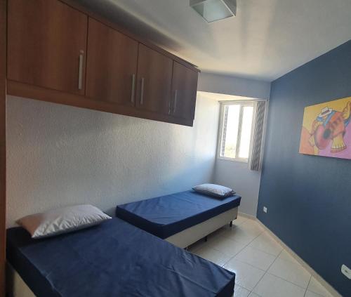 马蒂尼奥斯Apto Resort Cambuhy frente Mar até 6 pessoas的小房间设有两张床和窗户