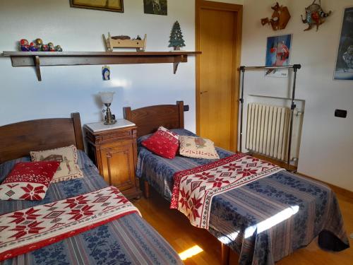 利维松多里Attico Vittoria的一间卧室设有两张床、一张桌子和一个架子。