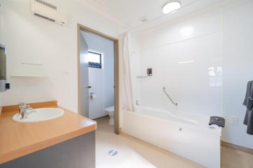 蒂阿瑙Te Anau Motel & Apartments的浴室配有盥洗盆和浴缸。