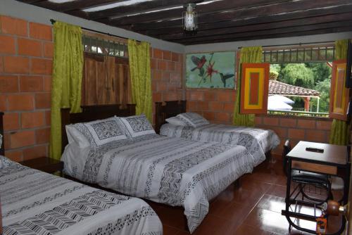 蒙特内哥罗Finca Hotel Villa Mariana的一间卧室设有两张床和砖墙